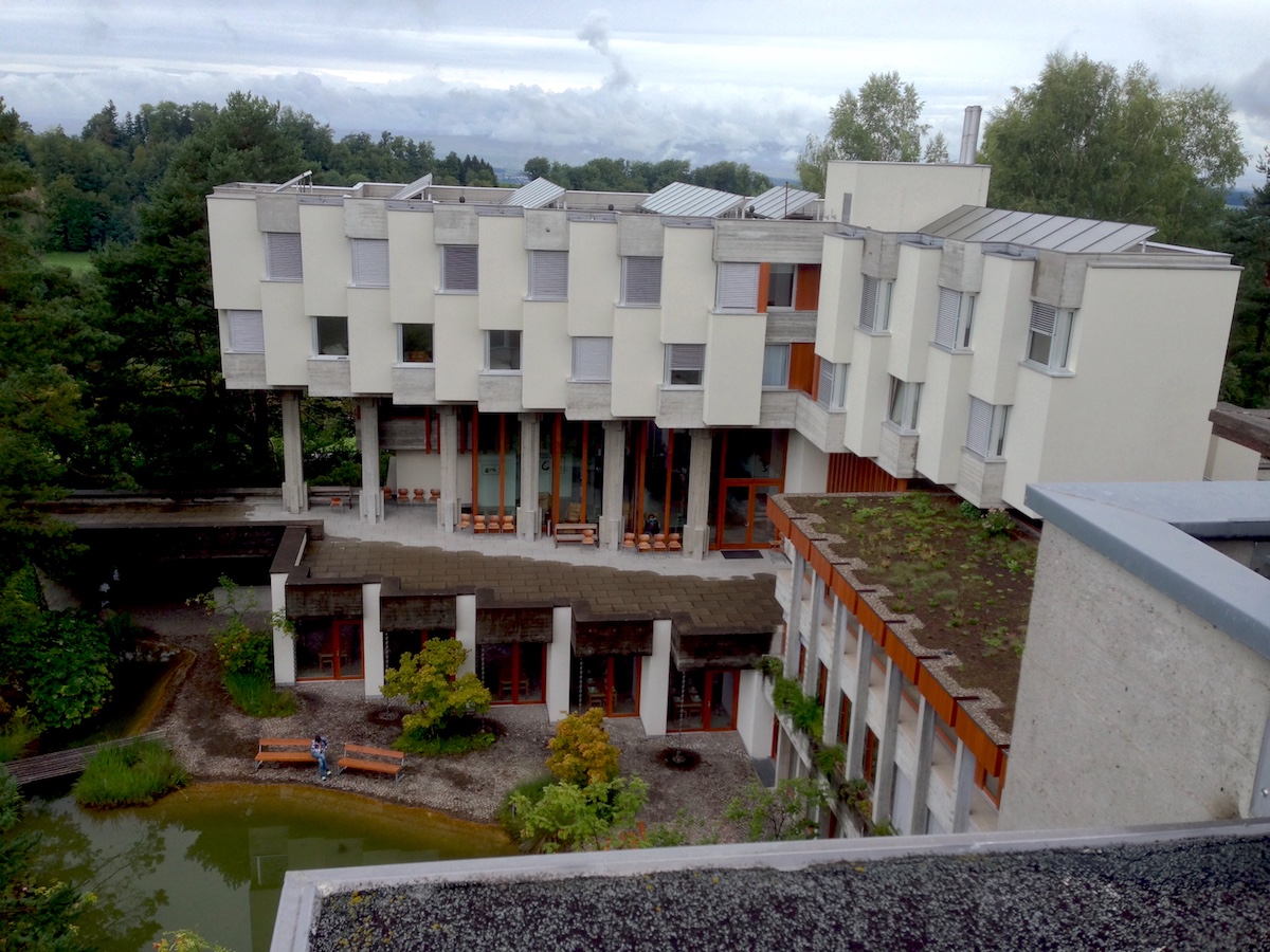 Das Lassalle-Haus ist U-förmig gebaut. In der Mitte liegt ein grüner Park mit Teich.